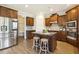 Beautiful kitchen with stainless steel appliances, wood cabinets, an island with seating, and hardwood floors at 107 Southern Acres Dr, Fuquay Varina, NC 27526