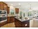 Kitchen featuring wood cabinets, granite countertops, stainless steel appliances, island with seating, and an open concept floor plan at 107 Southern Acres Dr, Fuquay Varina, NC 27526