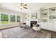 Cozy living room with large windows, built-in shelving, and a fireplace at 107 Southern Acres Dr, Fuquay Varina, NC 27526