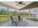 Relaxing screened-in porch featuring a ceiling fan, patio furniture, and views of the fenced backyard at 107 Southern Acres Dr, Fuquay Varina, NC 27526