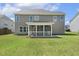 Rear view of home with gray siding, showcasing the cozy screened-in porch and manicured lawn at 107 Southern Acres Dr, Fuquay Varina, NC 27526