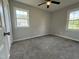 Spacious bedroom featuring new carpeting, two windows for natural light, and a modern ceiling fan at 109 Pine St, Dunn, NC 28334