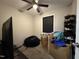 Cozy bedroom with blinds on the window, a modern ceiling fan, and personal items at 109 Pine St, Dunn, NC 28334