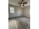 Well-lit bedroom with carpeting, a ceiling fan, and a window offering natural light at 109 Pine St, Dunn, NC 28334