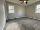 Bright bedroom featuring new carpeting, two windows for natural light, and a modern ceiling fan at 109 Pine St, Dunn, NC 28334