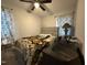 Cozy bedroom with neutral walls, ceiling fan, patterned curtains and comfortable bedding at 109 Pine St, Dunn, NC 28334