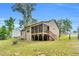 Exterior view of backyard featuring screened-in porch, fire pit, and spacious partially fenced yard at 114 Cherryhill Dr, Four Oaks, NC 27524