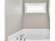 Close up of bathtub featuring a chrome faucet, window and light beige walls at 114 Cherryhill Dr, Four Oaks, NC 27524