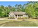 Charming single-story home featuring a cozy front porch, manicured landscaping, and a lush, wooded backdrop at 114 Cherryhill Dr, Four Oaks, NC 27524