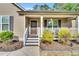 Charming front porch featuring a 'Welcome' sign, decorative wreath, and inviting decor, enhancing curb appeal at 114 Cherryhill Dr, Four Oaks, NC 27524