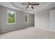 Spacious carpeted bedroom with recessed ceilings, windows providing ample natural light and green views at 114 Lynnville Ct, Lillington, NC 27546