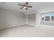 Spacious bedroom with neutral carpet, ceiling fan, a window, and a view of the house next door at 114 Lynnville Ct, Lillington, NC 27546