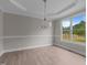 Dining room with elegant chandelier, tray ceiling, and large windows overlooking the yard at 114 Lynnville Ct, Lillington, NC 27546