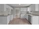 Renovated kitchen with white cabinets, granite counters, stainless sink, and a view to another room at 114 Lynnville Ct, Lillington, NC 27546