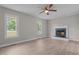 Bright living room featuring a fireplace, wood-look floors, and two large windows at 114 Lynnville Ct, Lillington, NC 27546