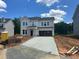 New two-story home with a concrete driveway and front yard, set in a new community with lush trees at 1248 Randwick Valley Ct, Zebulon, NC 27597