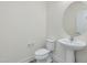 Chic powder room featuring a pedestal sink and round mirror at 1248 Randwick Valley Ct, Zebulon, NC 27597