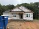Exterior home view with covered front porch and double-hung windows amid construction and wooded backdrop at 13159 S Nc-231 Hwy, Middlesex, NC 27557