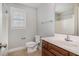 Bright bathroom featuring a sink with a dark wood vanity, toilet, tiled floor and a shower with tub for added convenience at 141 Shad Boat Ln, Clayton, NC 27520