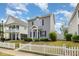 Two-story home with gray siding, black shutters, tidy landscaping and charming white picket fence at 141 Shad Boat Ln, Clayton, NC 27520