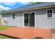 Home exterior featuring wood deck, light gray vinyl siding, mature landscaping, and a sliding glass door at 144 Holly Mountain Rd, Holly Springs, NC 27540