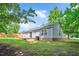 Home featuring a grassy backyard, gray vinyl siding, a wood deck, and mature trees and landscaping at 144 Holly Mountain Rd, Holly Springs, NC 27540