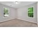 Neutral bedroom featuring plush carpet, light gray walls, and bright natural light from two windows at 144 Holly Mountain Rd, Holly Springs, NC 27540