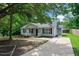 Inviting home with a cozy front porch, gray siding, black shutters, and a well-maintained front yard at 144 Holly Mountain Rd, Holly Springs, NC 27540