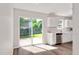 Bright kitchen featuring white cabinets, stainless steel appliances, and sliding glass door to the backyard deck at 144 Holly Mountain Rd, Holly Springs, NC 27540