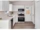Bright kitchen with white cabinetry, stainless steel appliances, and modern fixtures, next to the backdoor at 144 Holly Mountain Rd, Holly Springs, NC 27540