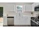 Well-lit kitchen featuring white cabinetry, stainless steel appliances, quartz counters, and contemporary design at 144 Holly Mountain Rd, Holly Springs, NC 27540