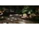 Outdoor lighting accents the backyard patio and waterfall, creating a serene ambiance for nighttime enjoyment at 15 Aman Ct, Durham, NC 27713