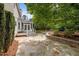 Charming flagstone backyard patio with a stone retaining wall and lush landscaping around the house at 15 Aman Ct, Durham, NC 27713