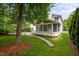 Exterior of the home with a screened-in porch and flagstone patio surrounded by mature trees and landscaping at 15 Aman Ct, Durham, NC 27713
