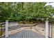 Stone patio overlooking a lushly landscaped backyard with retaining walls and mature trees at 15 Aman Ct, Durham, NC 27713