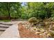 Idyllic backyard waterfall surrounded by lush landscaping and a flagstone patio at 15 Aman Ct, Durham, NC 27713
