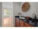 Elegant bar area with granite countertops, cherry cabinets, and stylish decor at 15 Aman Ct, Durham, NC 27713