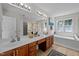 Elegant bathroom with double vanities, large mirror, and a separate tub at 15 Aman Ct, Durham, NC 27713