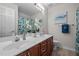 Well-lit bathroom featuring double sinks, cherry wood cabinets, and a decorative mirror at 15 Aman Ct, Durham, NC 27713
