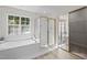Bright bathroom featuring a soaking tub with jets and a glass-enclosed shower at 15 Aman Ct, Durham, NC 27713