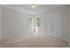 Neutral bedroom featuring plush carpet, a bright window, and a spacious closet at 15 Aman Ct, Durham, NC 27713