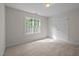 Cozy bedroom featuring plush carpet, a bright window, and a spacious closet at 15 Aman Ct, Durham, NC 27713