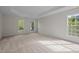 Spacious, light-filled carpeted bedroom with large windows and a tray ceiling at 15 Aman Ct, Durham, NC 27713