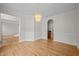 Open-concept dining area featuring hardwood floors, chandelier, and arched doorway at 15 Aman Ct, Durham, NC 27713