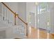 Bright foyer featuring hardwood floors, staircase with carpet runner, and tall windows at 15 Aman Ct, Durham, NC 27713