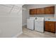 Well-equipped laundry room with cabinets, sink, washer, dryer, and metal shelving at 15 Aman Ct, Durham, NC 27713
