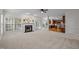 Open living room with a fireplace, neutral carpet, and a view of the kitchen at 15 Aman Ct, Durham, NC 27713