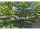 Spacious backyard showcasing the patio and mature trees providing ample shade on a sunny day at 151 Cobble Ridge Dr, Pittsboro, NC 27312