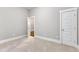 Neutral carpeted bedroom featuring a door, an open closet, and white trim at 151 Cobble Ridge Dr, Pittsboro, NC 27312