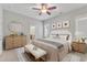 A staged main bedroom with a ceiling fan, a sitting area, and light colored walls at 151 Cobble Ridge Dr, Pittsboro, NC 27312